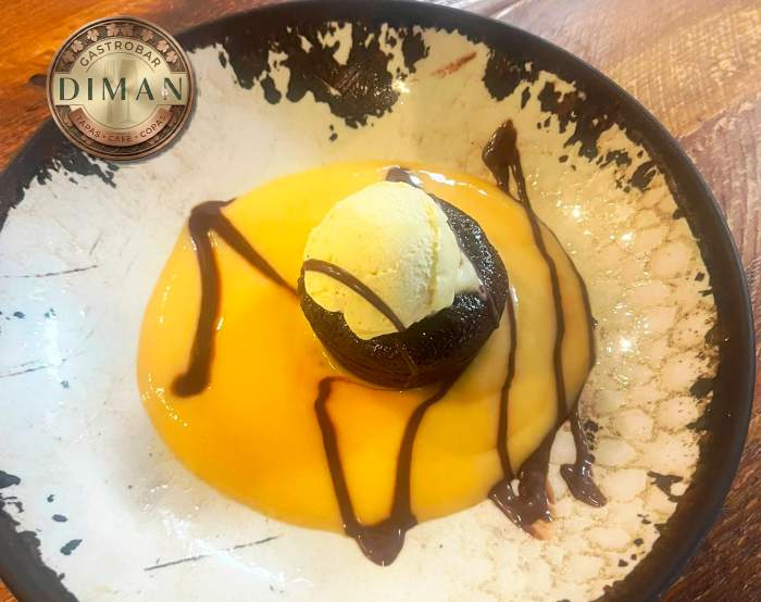 Delicioso Coulant de Chocolate sobre base de natilla acompañado de bola de helado artesano de vainilla